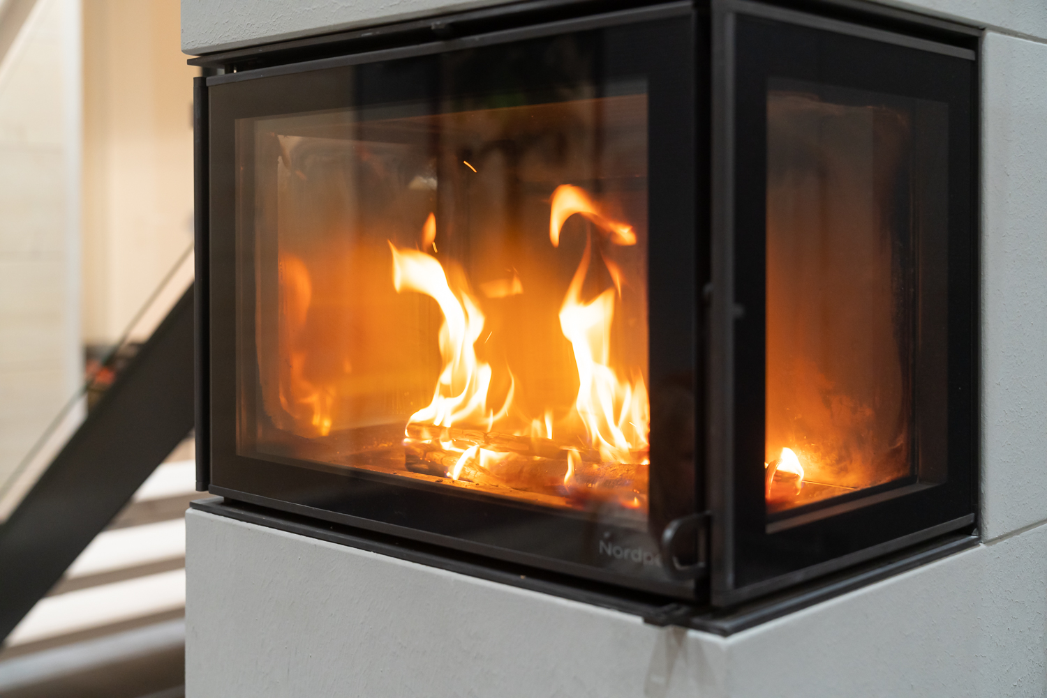 A photo of a lit wood burning stove in the Pyhakoski log home