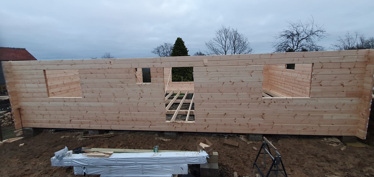 Photo of the front facade of the log cabin annexe under construction
